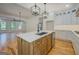 Modern kitchen island with stainless steel sink, wooden cabinets and a view into the living area at 5106 N Pratt St, Covington, GA 30014