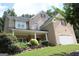 Charming two-story brick home featuring a welcoming front porch and attached two-car garage at 305 Matthew Cir, Stockbridge, GA 30252