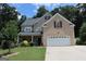 Inviting brick two-story home featuring a well-manicured lawn, two-car garage and charming front porch at 305 Matthew Cir, Stockbridge, GA 30252