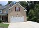 Charming brick home with attached two-car garage and lush landscaping at 305 Matthew Cir, Stockbridge, GA 30252