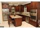 Well-equipped kitchen features dark wood cabinetry, granite countertops, stainless steel appliances and an island at 305 Matthew Cir, Stockbridge, GA 30252