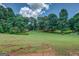An expansive backyard featuring a well-maintained lawn and mature trees that provide shade and privacy at 1615 Clairmont Sw Ln, Conyers, GA 30094