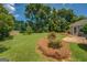 Manicured backyard features mature trees, green grass and established landscaping at 1615 Clairmont Sw Ln, Conyers, GA 30094