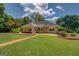 Backyard features large manicured lawn with mature landscaping and flowering plants at 1615 Clairmont Sw Ln, Conyers, GA 30094