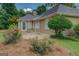 Landscaped backyard featuring lush plantings, a paved patio, and exterior access to the home at 1615 Clairmont Sw Ln, Conyers, GA 30094