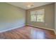 Neutral bedroom features hardwood floors, overhead lighting, and a large window at 1615 Clairmont Sw Ln, Conyers, GA 30094