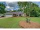 Beautifully maintained home features a lush lawn, trimmed landscape, and an attached garage at 1615 Clairmont Sw Ln, Conyers, GA 30094