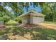 A detached garage with a white door, surrounded by greenery and a well-maintained yard at 1615 Clairmont Sw Ln, Conyers, GA 30094
