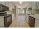 Spacious kitchen with white cabinets, marble countertops, black appliances, and tile flooring at 1615 Clairmont Sw Ln, Conyers, GA 30094