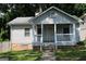 Charming bungalow with a covered front porch, stone foundation, and mature trees at 1627 Orlando Sw St, Atlanta, GA 30311
