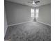 Cozy bedroom featuring neutral walls, plush carpeting, and a double window providing natural light at 7910 Tintern Trce, Duluth, GA 30097