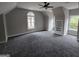 Large bedroom with plush carpeting, neutral walls, and ample natural light from the arched window at 7910 Tintern Trce, Duluth, GA 30097