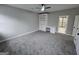Spacious bedroom with plush gray carpet, a ceiling fan, a built-in bookshelf, and an attached bath at 7910 Tintern Trce, Duluth, GA 30097