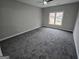 Large, carpeted bedroom with a ceiling fan and a large window overlooking the neighborhood at 7910 Tintern Trce, Duluth, GA 30097