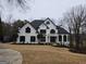 Elegant white house features a manicured lawn, black shutters, and a stately entrance with pillars and balcony at 7910 Tintern Trce, Duluth, GA 30097