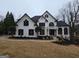 Stunning two-story home with a white stucco exterior, black shutters, a circular balcony, and professionally landscaped yard at 7910 Tintern Trce, Duluth, GA 30097