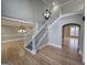 Light-filled foyer with hardwood floors, white staircase, elegant chandeliers, and views of the living spaces at 7910 Tintern Trce, Duluth, GA 30097