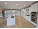 Open concept kitchen with stainless steel appliances, white cabinets, quartz island, and hardwood floors at 7910 Tintern Trce, Duluth, GA 30097
