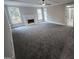 Spacious living room with plush carpet, fireplace, multiple windows providing natural light, and ceiling fan at 7910 Tintern Trce, Duluth, GA 30097