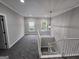 Upstairs landing featuring a window, carpeted floor, and stairs at 7910 Tintern Trce, Duluth, GA 30097