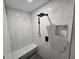 Walk-in shower featuring elegant marble tile, a built-in seat and a modern shower head at 7910 Tintern Trce, Duluth, GA 30097