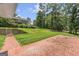 Expansive grassy backyard featuring a large brick patio, mature landscaping, and view of the home at 708 Delanie Way, Stone Mountain, GA 30083