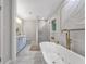 A luxurious bathroom featuring marble floors, soaking tub, shower with glass, and double vanity at 708 Delanie Way, Stone Mountain, GA 30083