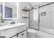 Bright bathroom featuring a modern vanity, updated fixtures, stylish lighting, and a glass-enclosed shower over tub at 708 Delanie Way, Stone Mountain, GA 30083
