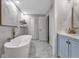 Bright bathroom featuring a soaking tub, tiled floors, a double vanity, and natural light at 708 Delanie Way, Stone Mountain, GA 30083