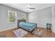 Bright bedroom with hardwood floors, two windows, a ceiling fan, and neutral walls, offering a relaxing space at 708 Delanie Way, Stone Mountain, GA 30083