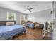 Bright bedroom featuring hardwood floors, two large windows, a ceiling fan, and a bookshelf at 708 Delanie Way, Stone Mountain, GA 30083