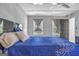 Cozy bedroom with a ceiling fan, two windows with gray curtains, and a patterned blue comforter at 708 Delanie Way, Stone Mountain, GA 30083