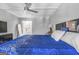 A spacious bedroom with modern ceiling fan, blue comforter, and an attached bathroom at 708 Delanie Way, Stone Mountain, GA 30083