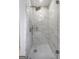 Elegant bathroom shower featuring marble-patterned tile, modern fixtures, and seamless glass doors at 708 Delanie Way, Stone Mountain, GA 30083
