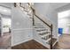 Beautiful staircase with wood treads, white risers, and decorative wall paneling adding a touch of sophistication at 708 Delanie Way, Stone Mountain, GA 30083