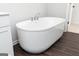 Close-up of a freestanding white soaking tub on wood-look floors at 714 Ocmulgee Crossing, Locust Grove, GA 30248