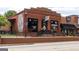 Charming brick commercial building with black framed windows and awnings, housing a 'Lovin' Oven' restaurant at 714 Ocmulgee Crossing, Locust Grove, GA 30248
