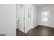 Hallway featuring wood-look floors, light gray walls and open door to living space at 714 Ocmulgee Crossing, Locust Grove, GA 30248