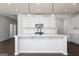 Modern kitchen featuring white cabinets, an island with seating, and pendant lighting at 714 Ocmulgee Crossing, Locust Grove, GA 30248