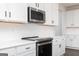 Modern kitchen featuring white cabinets, stainless steel appliances, and a sleek countertop at 714 Ocmulgee Crossing, Locust Grove, GA 30248