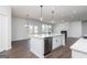 Bright, open-concept kitchen with an island, stainless steel appliances, and wood flooring at 714 Ocmulgee Crossing, Locust Grove, GA 30248