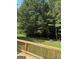 View of the property's spacious backyard from atop a wooden deck and railing at 276 Appalachee Church Rd, Auburn, GA 30011