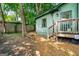 View of the backyard featuring the yard, trees, and a deck with wooden stairs at 216 Leyden St, Decatur, GA 30030