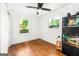 Spare bedroom featuring wood floors, wainscoting, a ceiling fan and two windows at 216 Leyden St, Decatur, GA 30030