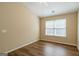 Bedroom with neutral walls, hardwood floors, and a large window at 2375 Lexington Ln, Cumming, GA 30040