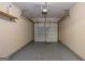 An empty one-car garage with gray painted floor and white paneled garage door at 2375 Lexington Ln, Cumming, GA 30040