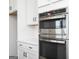 Close up of stainless steel microwave and oven inset into the modern white cabinets at 121 Chattahoochee Circle, Locust Grove, GA 30248