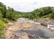 Panoramic landscape view of a rock-filled river with trees at 121 Chattahoochee Circle, Locust Grove, GA 30248