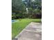 Backyard featuring green grass, a fenced yard, mature trees, and a glimpse of the covered swimming pool at 268 Rountree Rd, Riverdale, GA 30274