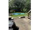 Backyard featuring an in-ground pool covered by a blue tarp, surrounded by green grass and mature trees at 268 Rountree Rd, Riverdale, GA 30274